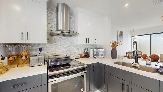 a kitchen with kitchen island a counter top space appliances and cabinets