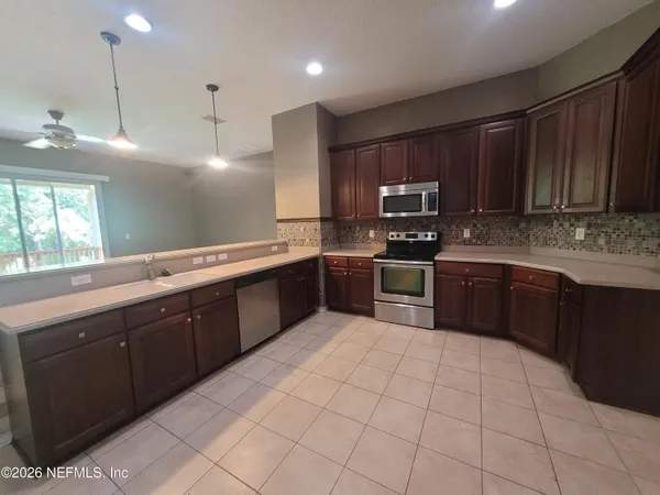 a kitchen with stainless steel appliances granite countertop a sink counter space cabinets and a large window