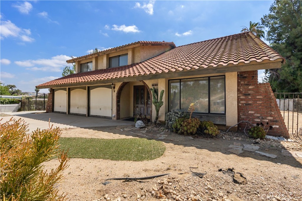 17656 Mockingbird Hill Circle Riverside, CA 92504 - Photo 2 of 49 a front view of a house with a yard and garage