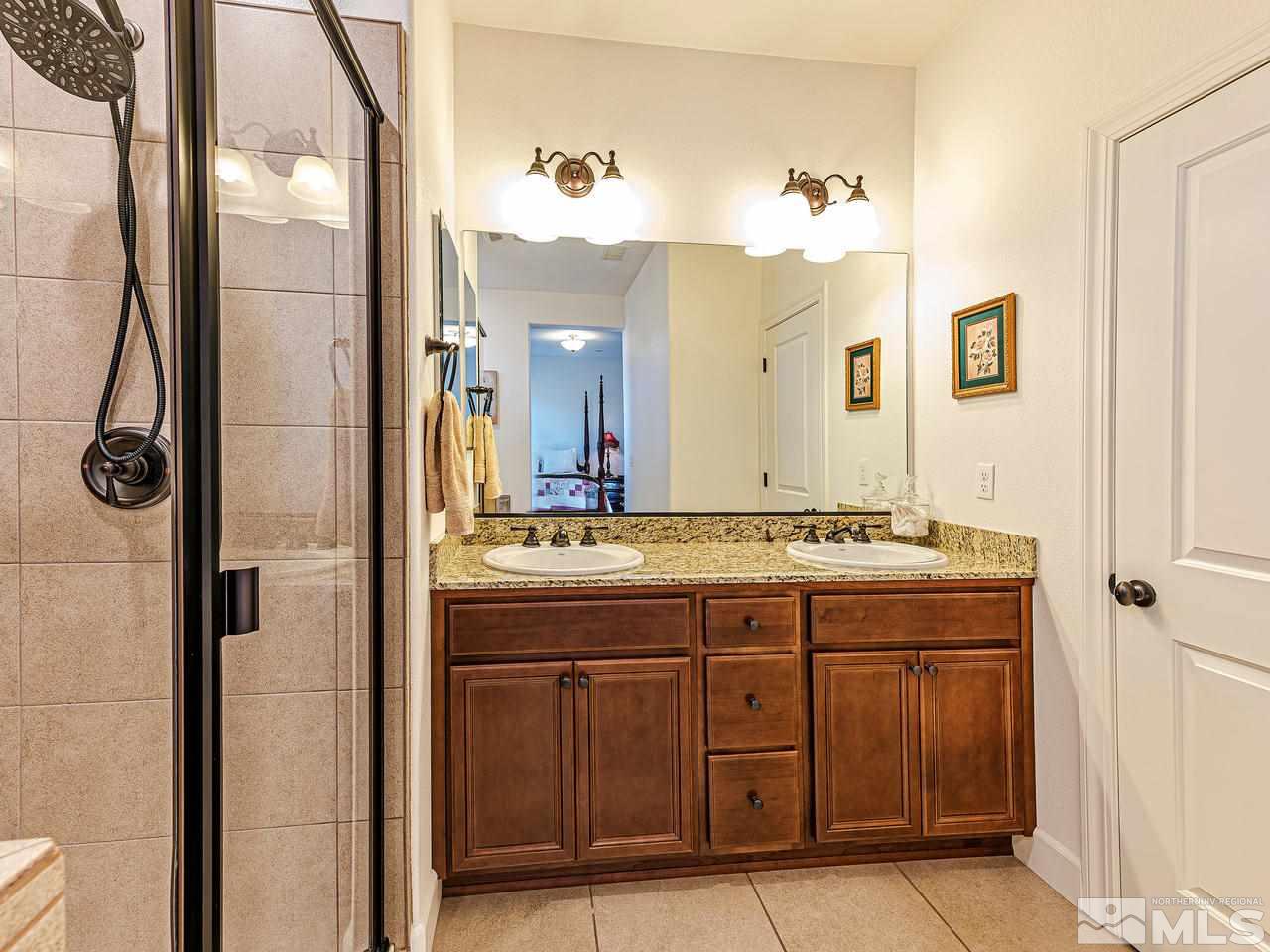 1890 Dark Horse Road, Unit 1062 Reno, NV 89521 - Photo 11 of 19 a bathroom with a granite countertop sink a mirror and a vanity