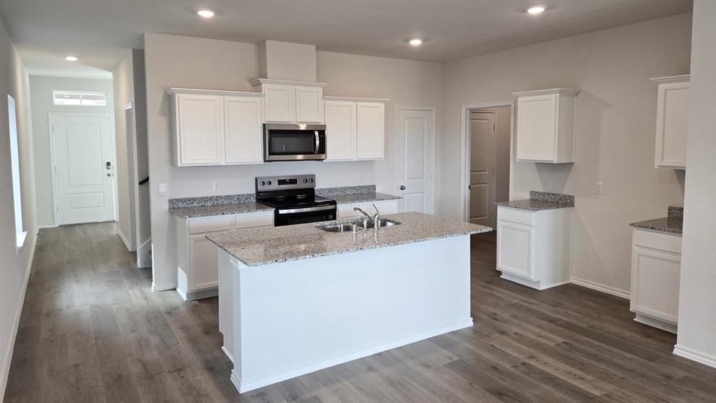 920 Jefferson Way Sherman, TX 75090 - Photo 14 of 21 a kitchen with stainless steel appliances a stove top oven a sink a refrigerator white cabinets and wooden floor