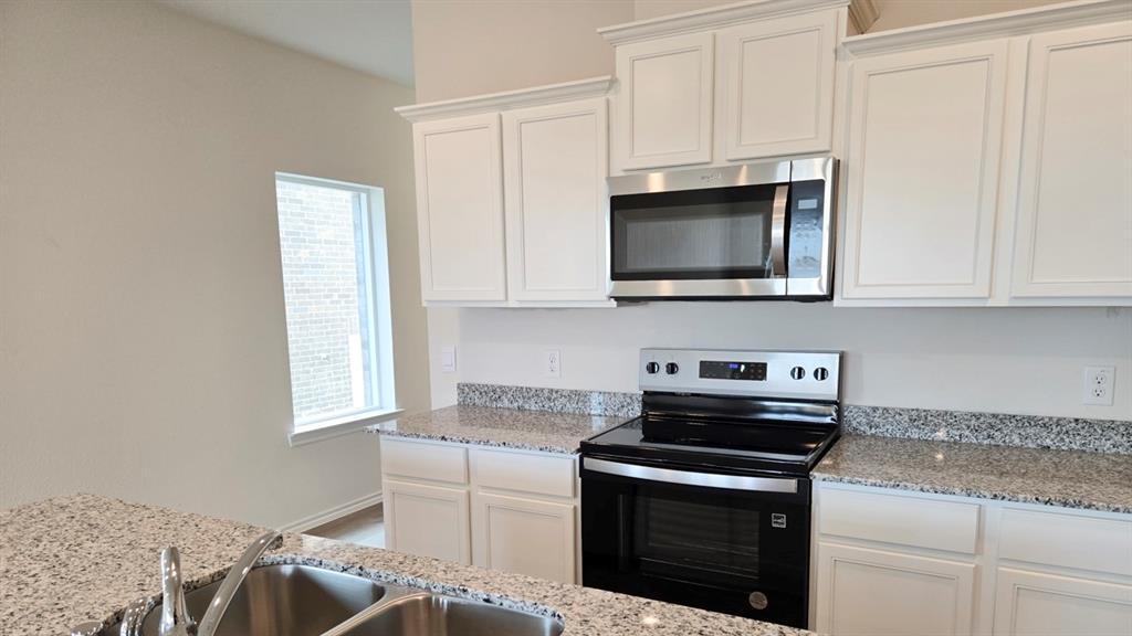 920 Jefferson Way Sherman, TX 75090 - Photo 17 of 21 a kitchen with stainless steel appliances granite countertop a stove microwave and sink