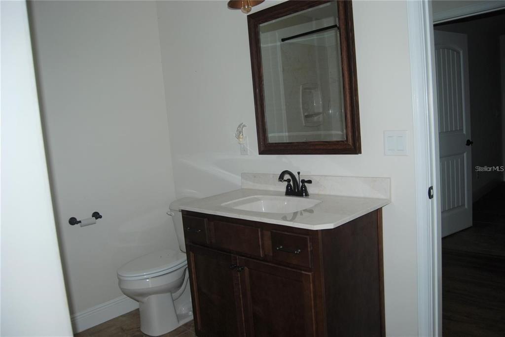 1167 Southeast 63rd Ct Road Ocala, FL 34472 - Photo 19 of 37 a bathroom with a granite countertop sink toilet and mirror