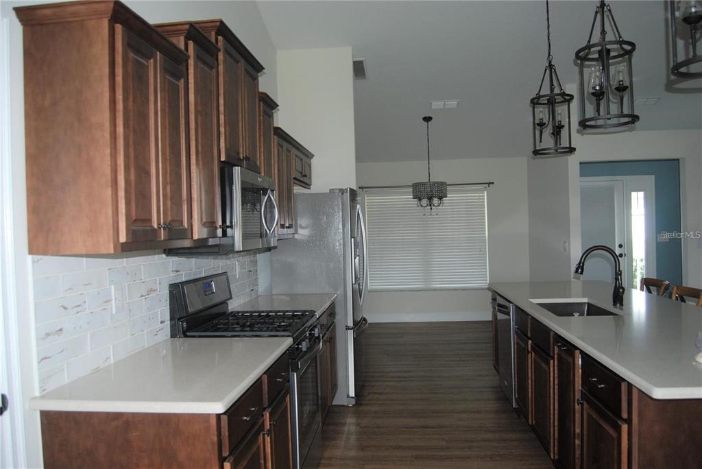 1167 Southeast 63rd Ct Road Ocala, FL 34472 - Photo 23 of 37 a kitchen with stainless steel appliances granite countertop a sink a stove and a refrigerator