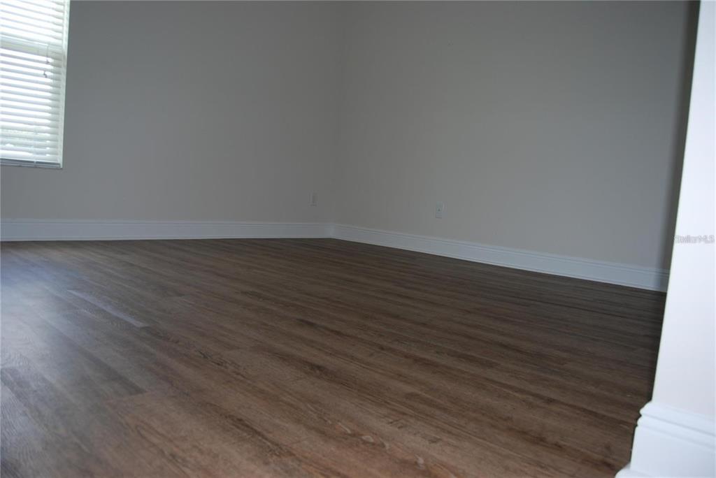1167 Southeast 63rd Ct Road Ocala, FL 34472 - Photo 24 of 37 an empty room with wooden floor and windows