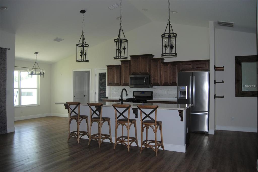 1167 Southeast 63rd Ct Road Ocala, FL 34472 - Photo 9 of 37 a view of a kitchen and dining room with wooden floor