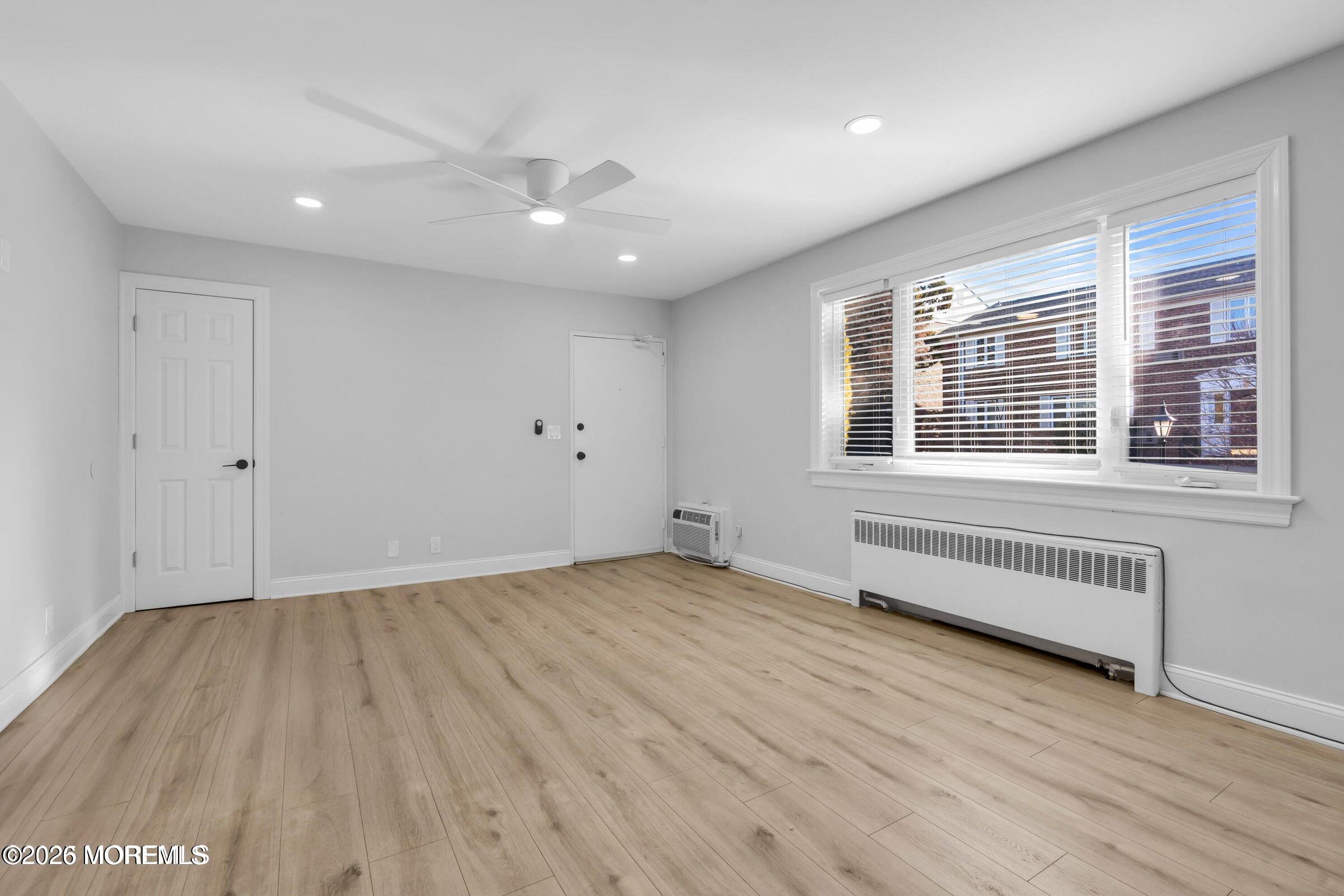 283 Spring Street, Unit 3A Red Bank, NJ 07701 - Photo 15 of 21 a view of an empty room with wooden floor and a window