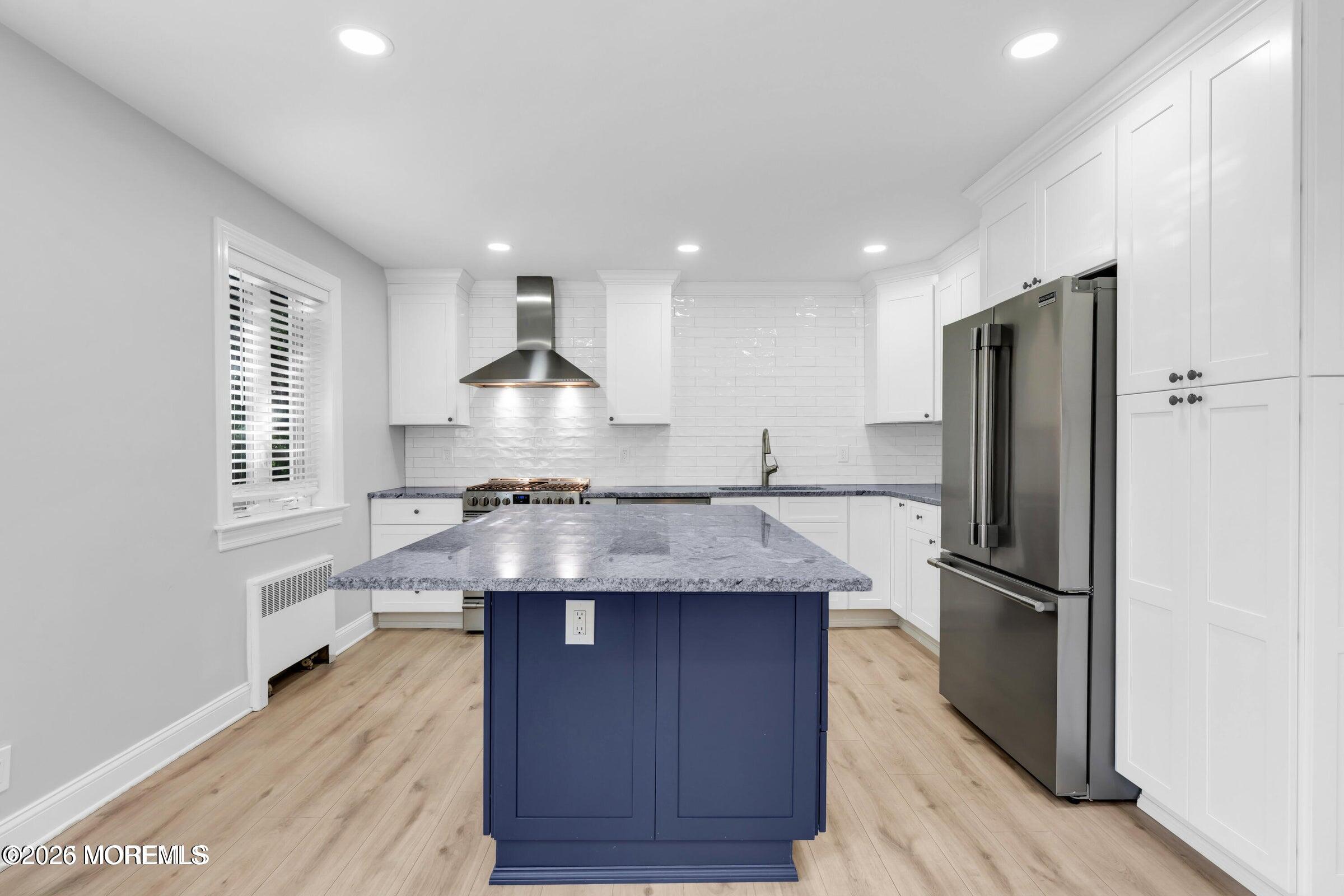 283 Spring Street, Unit 3A Red Bank, NJ 07701 - Photo 5 of 21 a kitchen with kitchen island granite countertop a sink and refrigerator