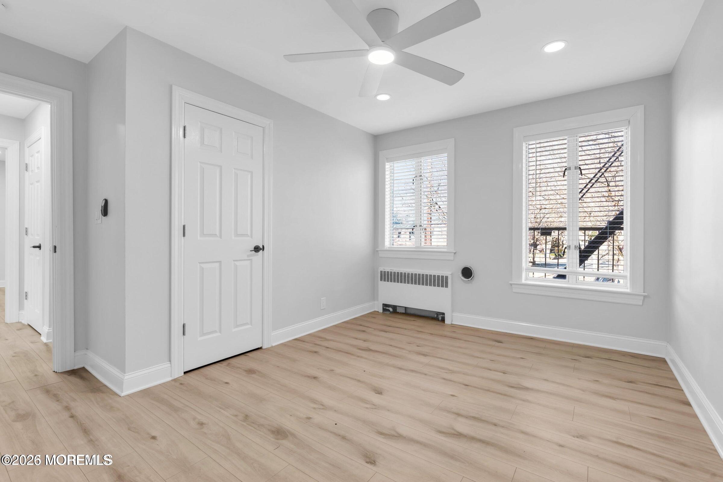 283 Spring Street, Unit 3A Red Bank, NJ 07701 - Photo 8 of 21 a view of an empty room with a window and wooden floor