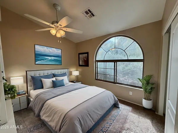 a bedroom with a large bed and a chandelier