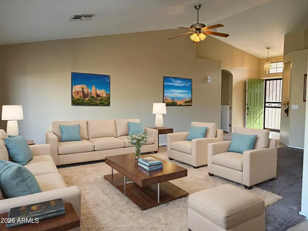 a living room with furniture a ceiling fan and a window