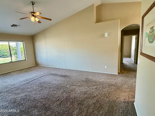 en empty room with windows and fan