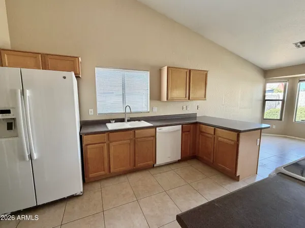 a kitchen with a sink a refrigerator a microwave and cabinets