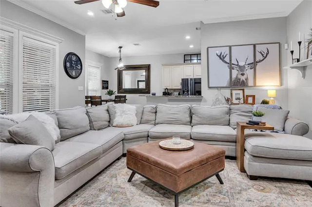 a living room with furniture a clock on wall and a window