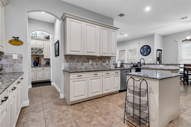 a kitchen with granite countertop a sink cabinets and stove