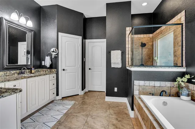 a bathroom with a tub a sink and mirror