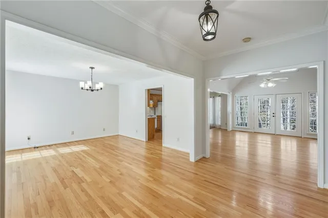 a view of a room with wooden floor ceiling fan and window