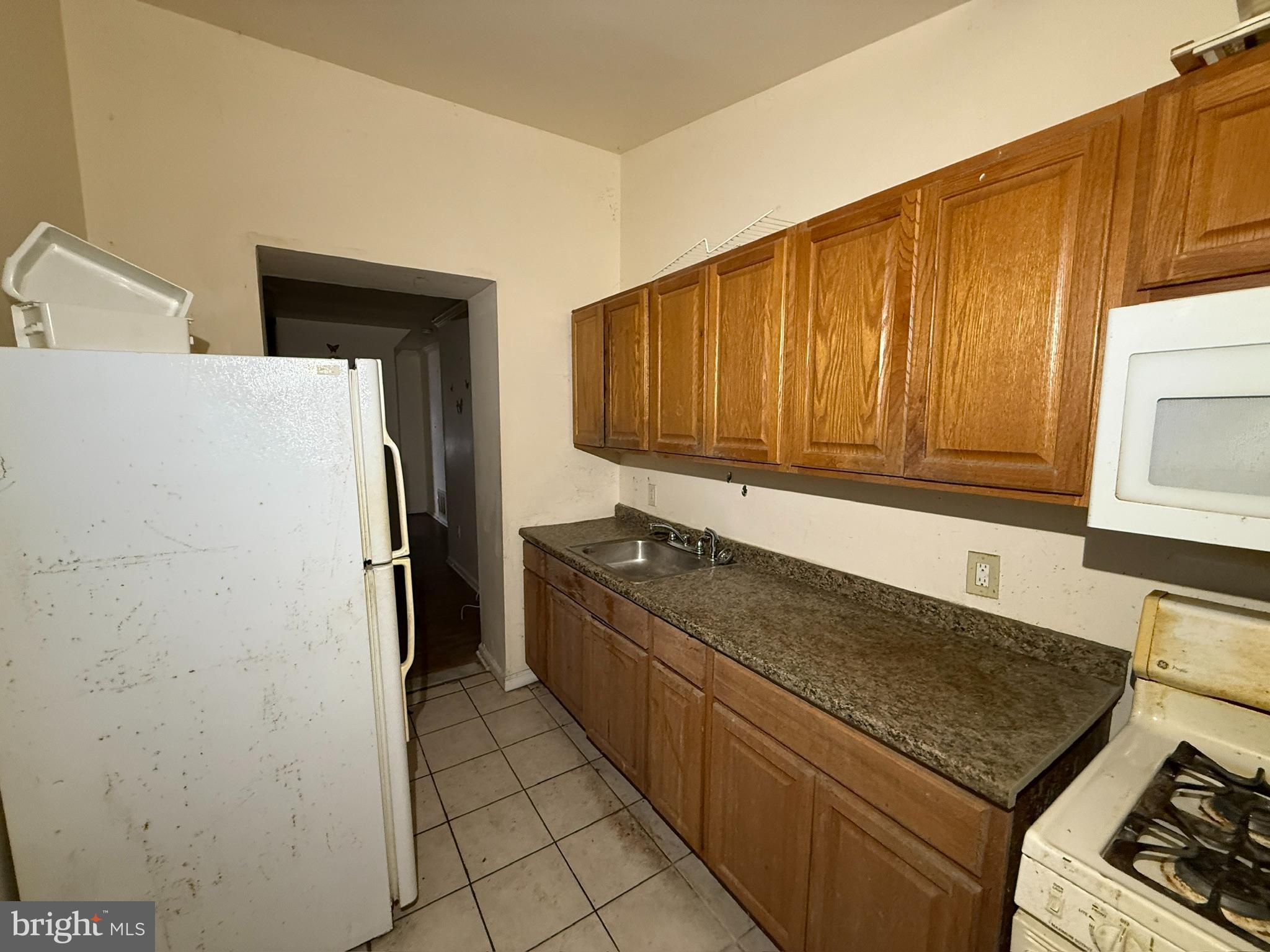 340 South Calhoun Street Baltimore, MD 21223 - Photo 6 of 15 a kitchen with a refrigerator sink and cabinets