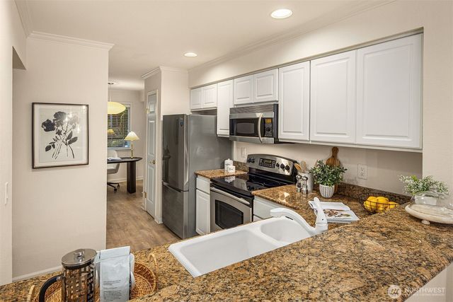 a kitchen with stainless steel appliances granite countertop a refrigerator stove microwave and sink