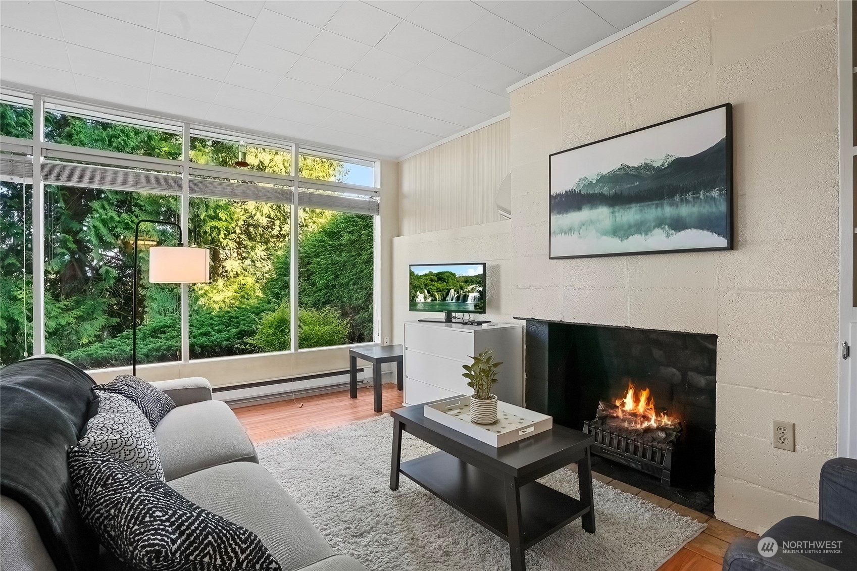 1104 39th Street Everett, WA 98201 - Photo 31 of 40 a living room with furniture a fireplace and a floor to ceiling window