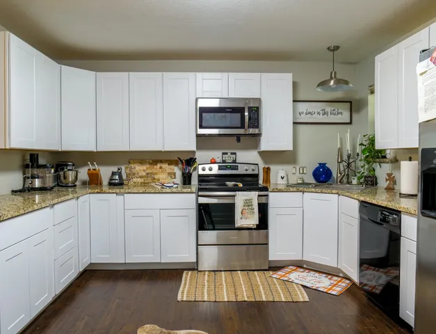 a kitchen with stainless steel appliances granite countertop a stove sink and cabinets