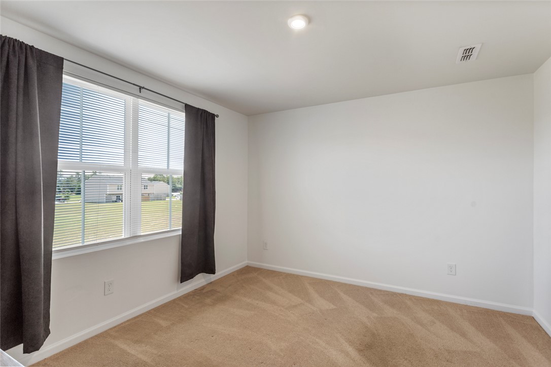 137 Nicklaus Drive Anderson, SC 29621 - Photo 20 of 37 An inviting secondary bedroom features soft carpet flooring and a large window with horizontal blinds.