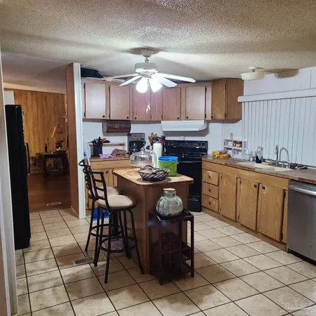 a kitchen with a sink dining table and chairs