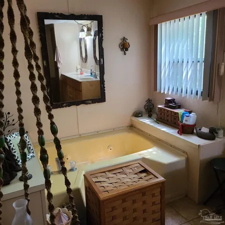 a bathroom with a tub sink and mirror