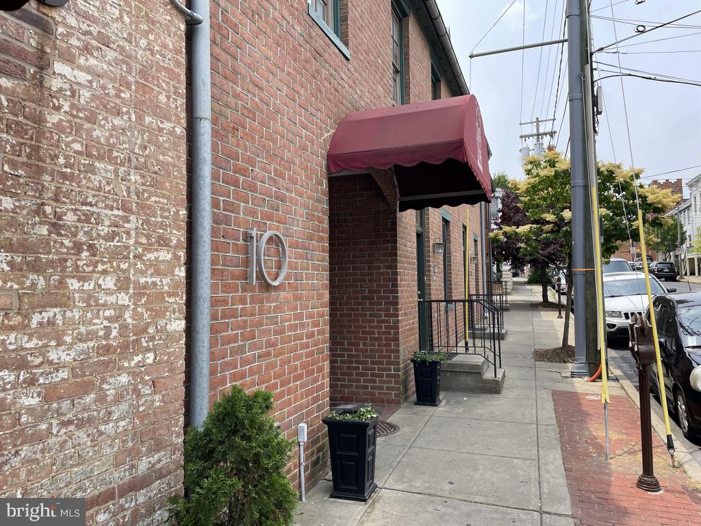 a view of a brick wall with a building in the background