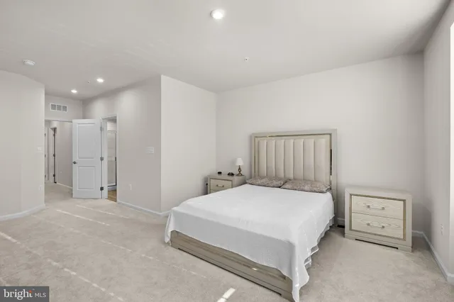 a bedroom with a bed and a refrigerator