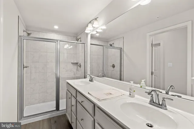 a bathroom with a double vanity sink mirror and shower