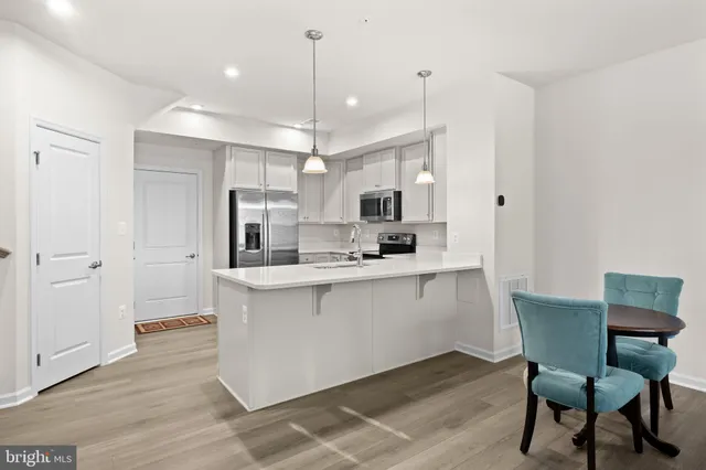 a kitchen with a table chairs refrigerator and microwave