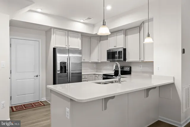 a kitchen with kitchen island a refrigerator sink and microwave