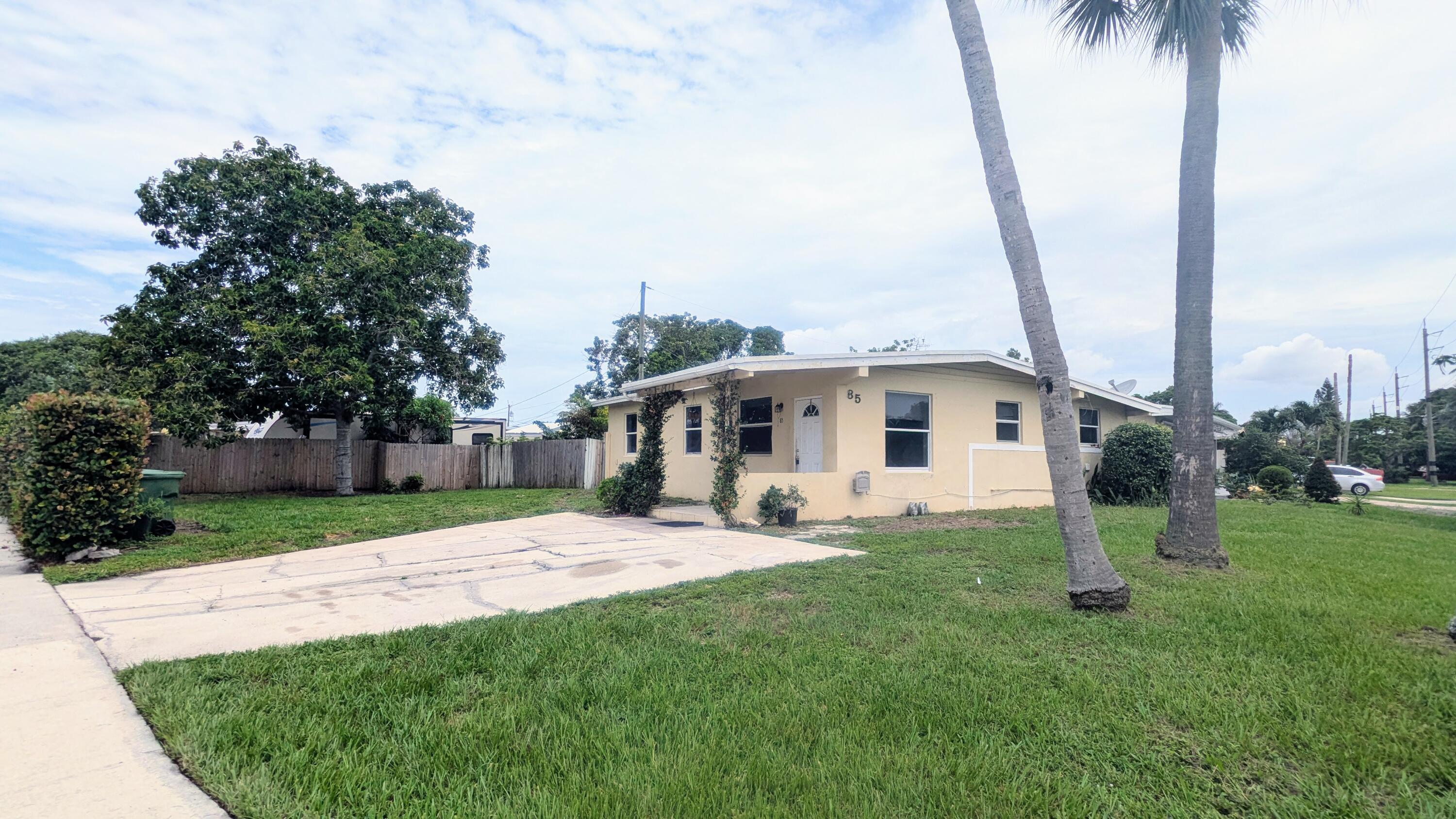 85 Morgans Way Palm Springs, FL 33461 - Photo 1 of 17 a house with palm tree in front of it