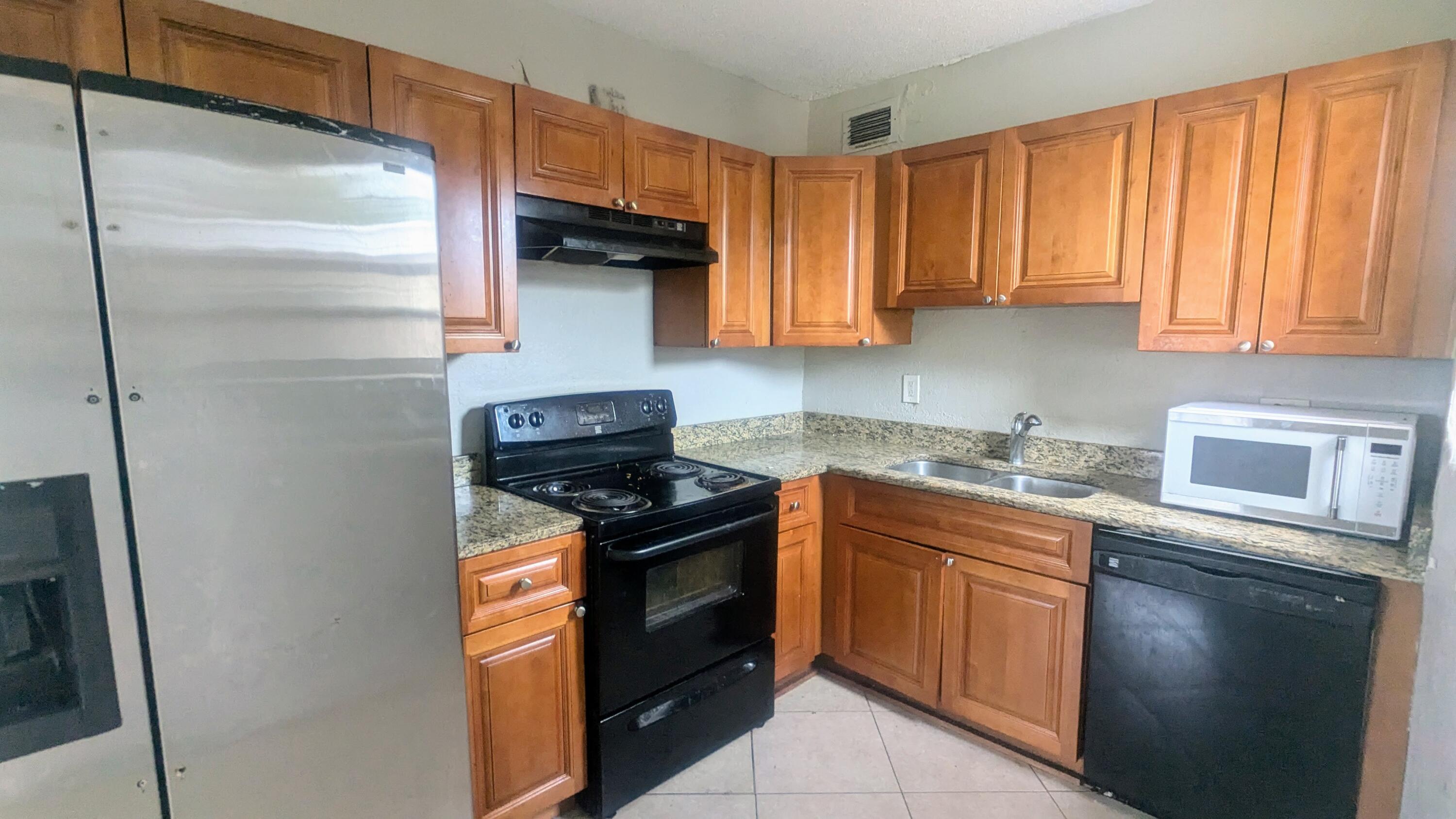 85 Morgans Way Palm Springs, FL 33461 - Photo 14 of 17 a kitchen with stainless steel appliances granite countertop a stove a refrigerator and a sink