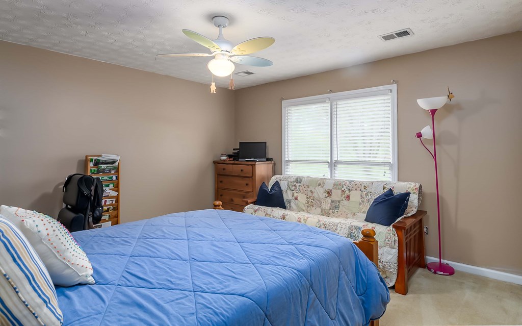 32 Bugle Brook Court Midland, GA 31820 - Photo 19 of 30 a bedroom with a bed and a chandelier