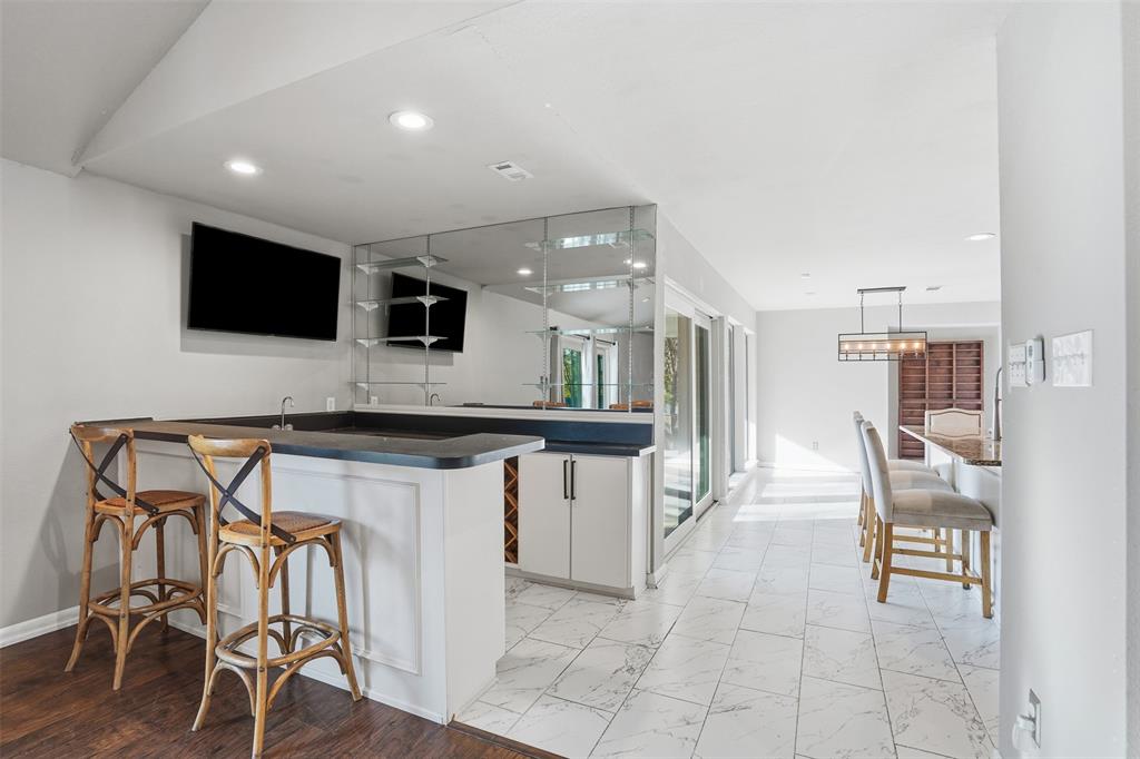 704 Timberview Court North Fort Worth, TX 76112 - Photo 14 of 40 a kitchen with a table chairs refrigerator and microwave