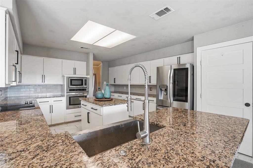 704 Timberview Court North Fort Worth, TX 76112 - Photo 18 of 40 a living room with furniture a rug and kitchen view