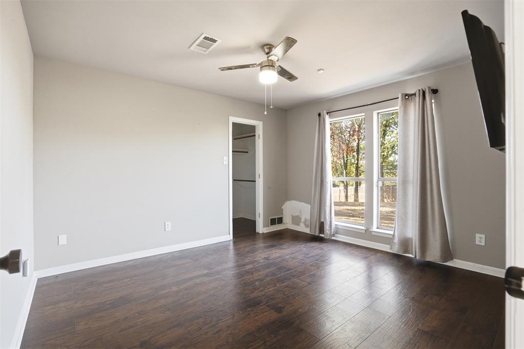 704 Timberview Court North Fort Worth, TX 76112 - Photo 23 of 40 a view of an empty room with a window and wooden floor