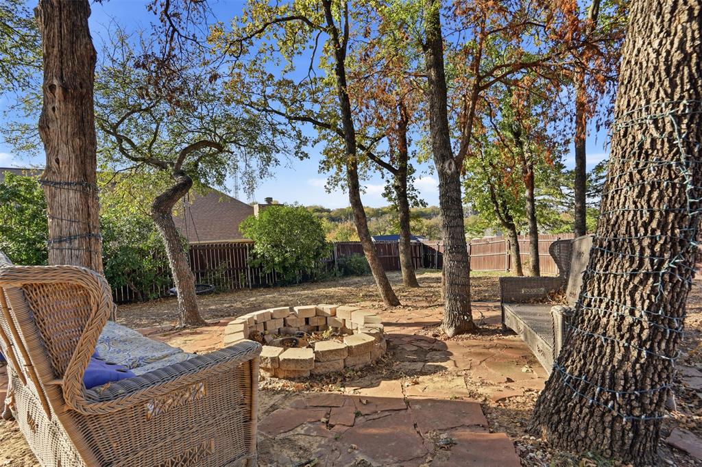 704 Timberview Court North Fort Worth, TX 76112 - Photo 36 of 40 a view of backyard with outdoor seating and trees