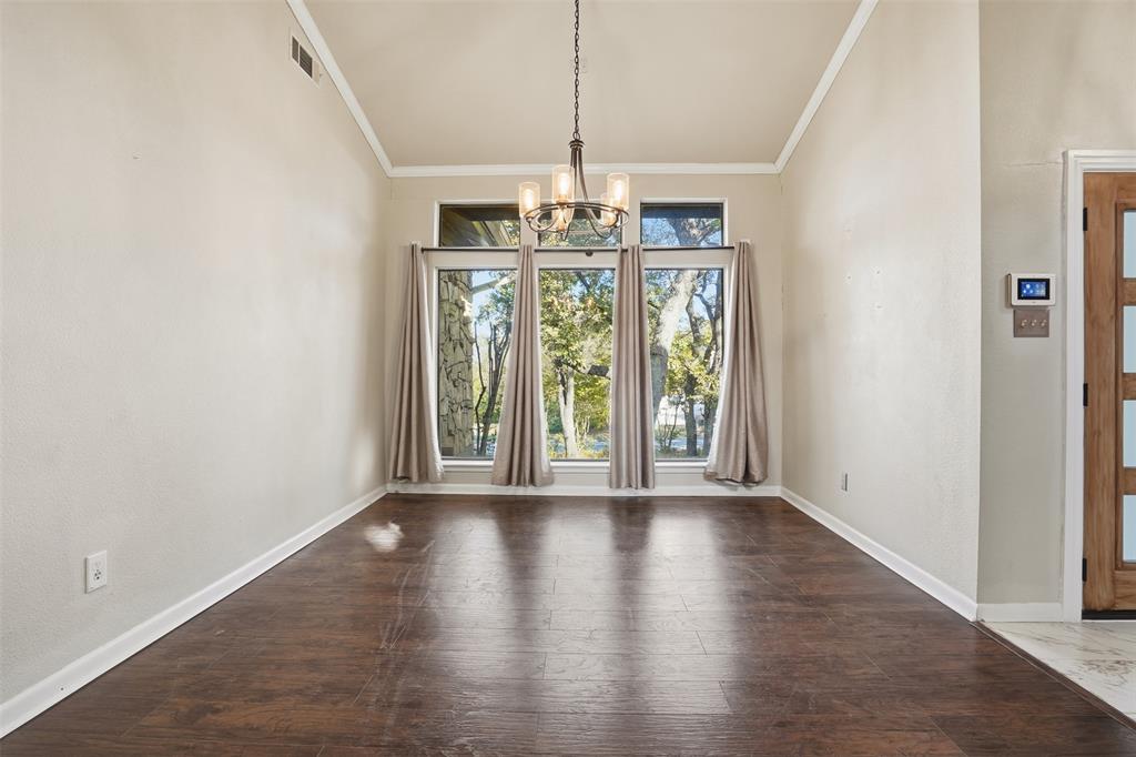 704 Timberview Court North Fort Worth, TX 76112 - Photo 7 of 40 a view of a hallway with wooden floor and chandelier
