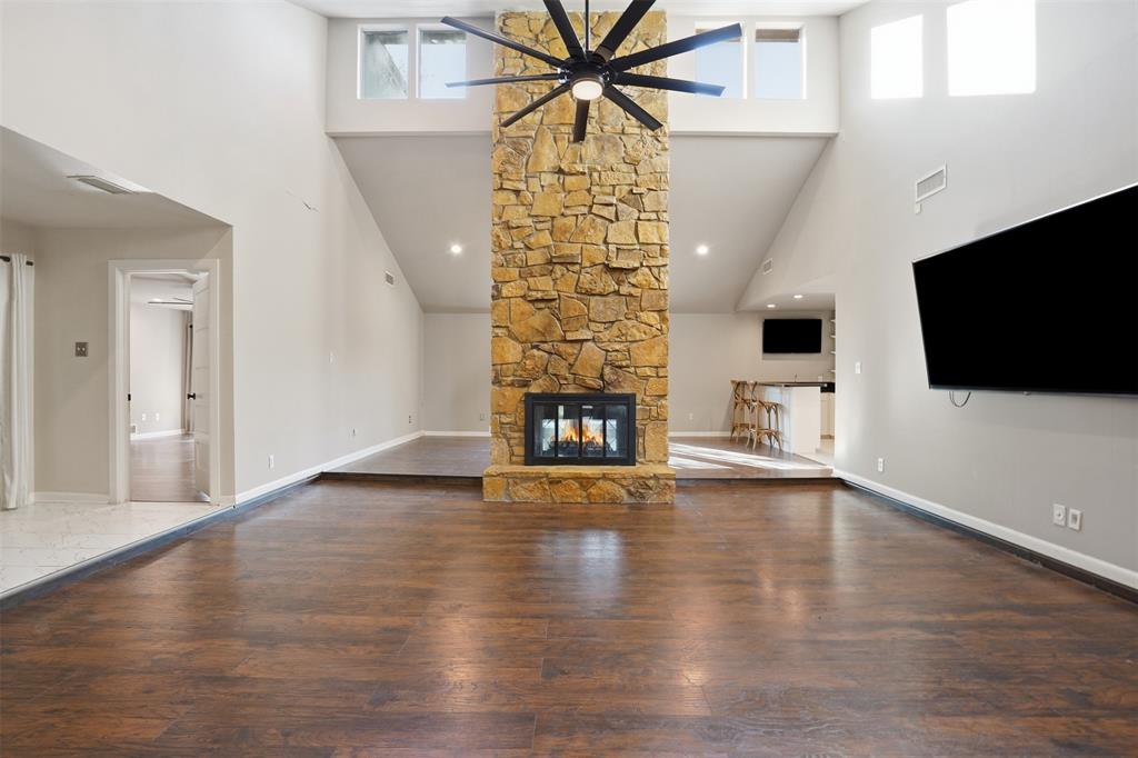 704 Timberview Court North Fort Worth, TX 76112 - Photo 9 of 40 a view of an empty room with wooden floor and a fireplace