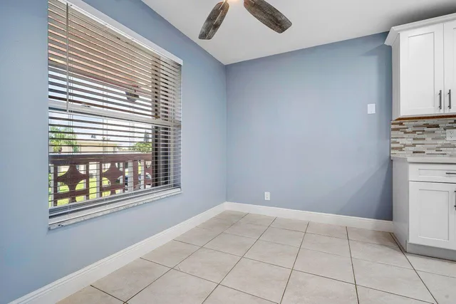 a view of an empty room with a window and kitchen