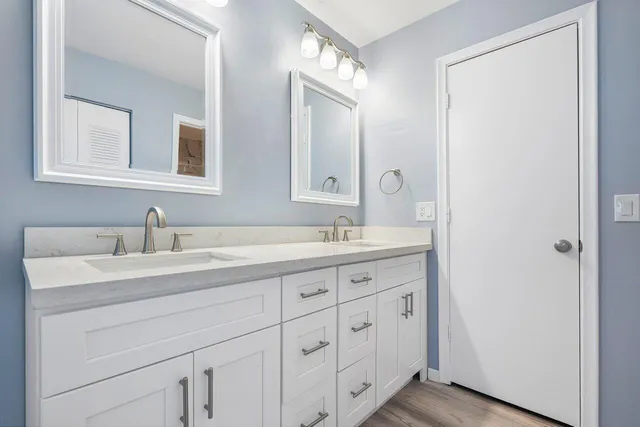 a bathroom with double sink and a mirror