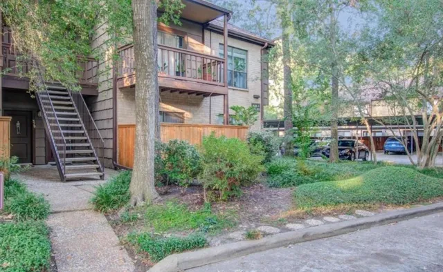 a view of a brick house with a yard and plants