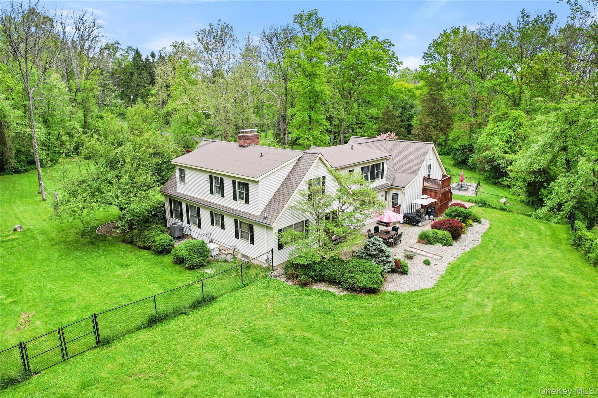 view of a house with a big yard and large trees