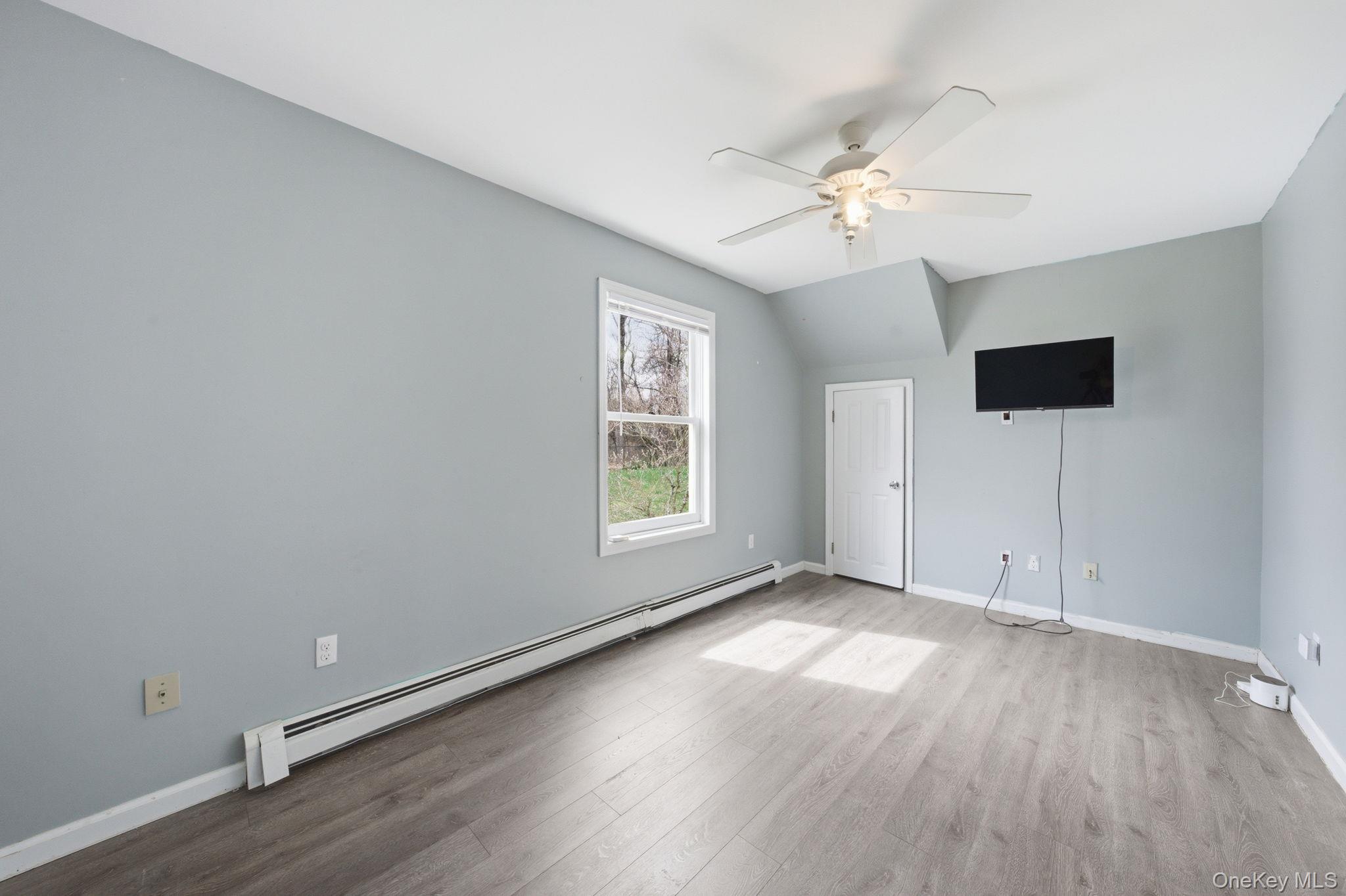 83 Onderdonk Road Warwick, NY 10990 - Photo 25 of 40 an empty room with wooden floor chandelier fan and windows