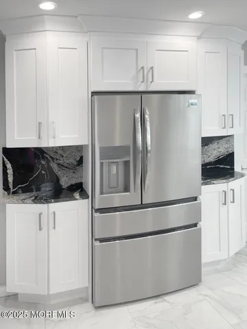 a kitchen with stainless steel appliances granite countertop a refrigerator and a stove