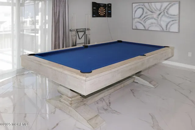 a room with pool table and windows