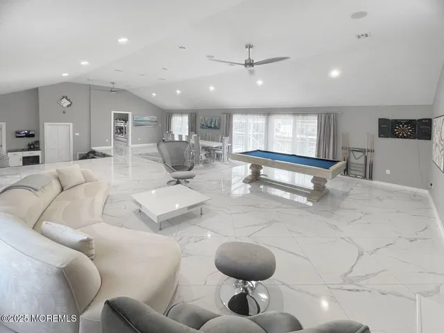 a living room with furniture and a view of kitchen